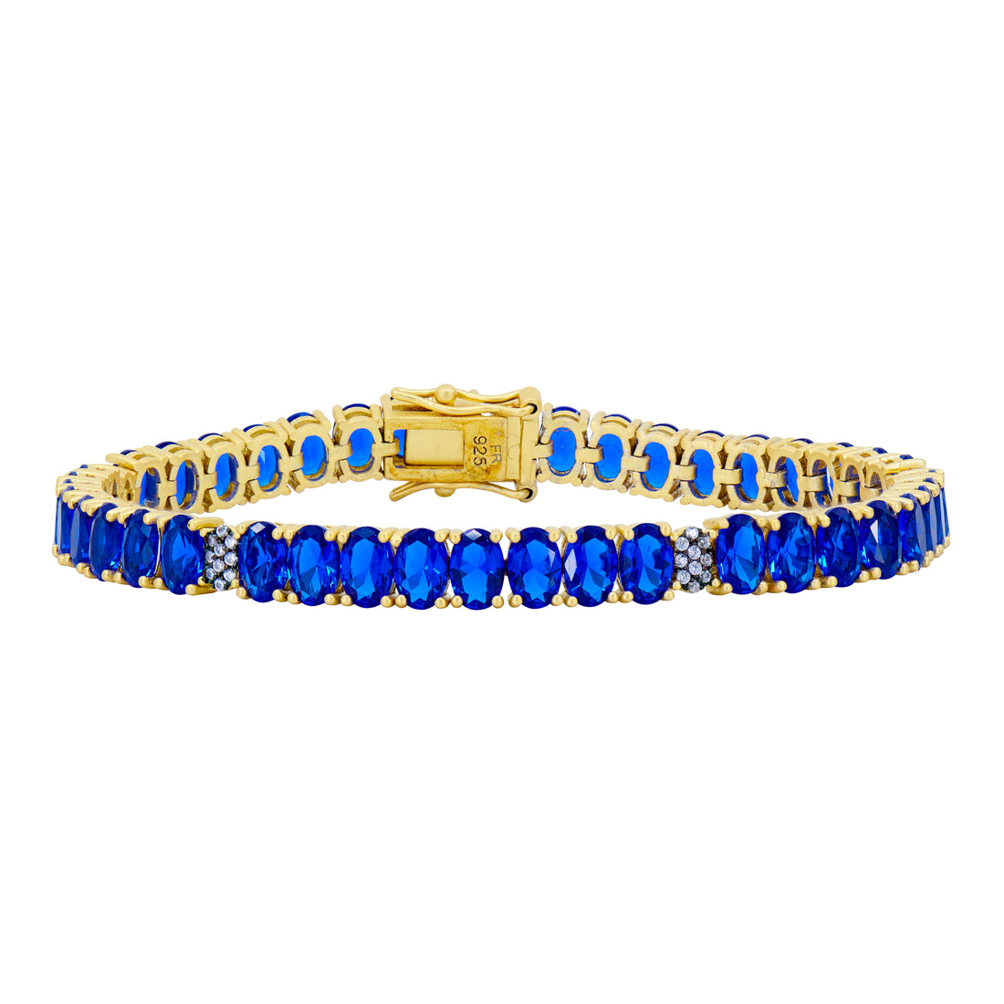 The Midnight Tri-Tone Twilight Oval Station Tennis Bracelet by Midnight is an exquisite piece crafted from 14K matte gold. It is adorned with a series of oval-cut deep blue gemstones and sparkling cubic zirconia stones, and features a clasp with a small metal tag. The continuous pattern of this bracelet is truly captivating.